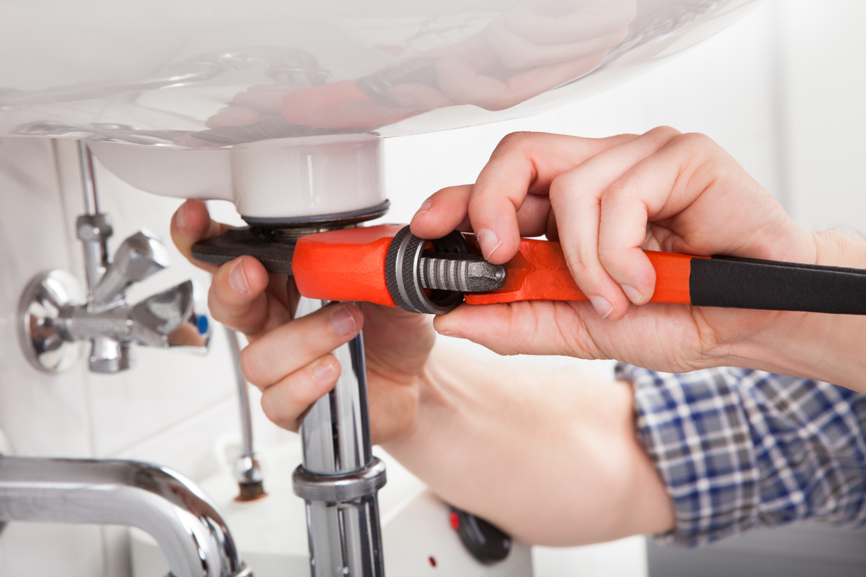 A plumber fixing a sink in a bathroom