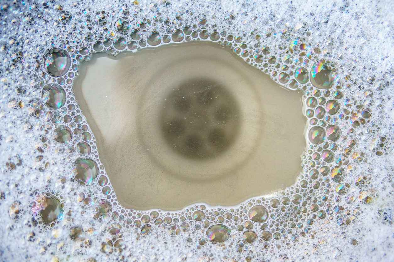 White clogged toilet with plunger